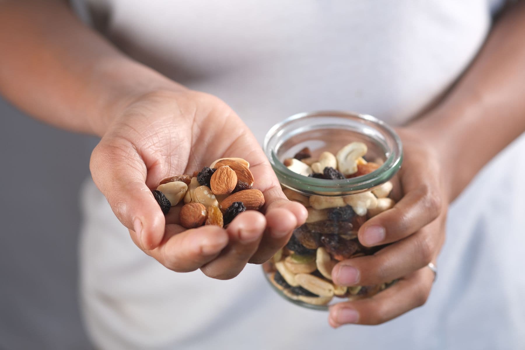 Hand holding a scoop of nuts