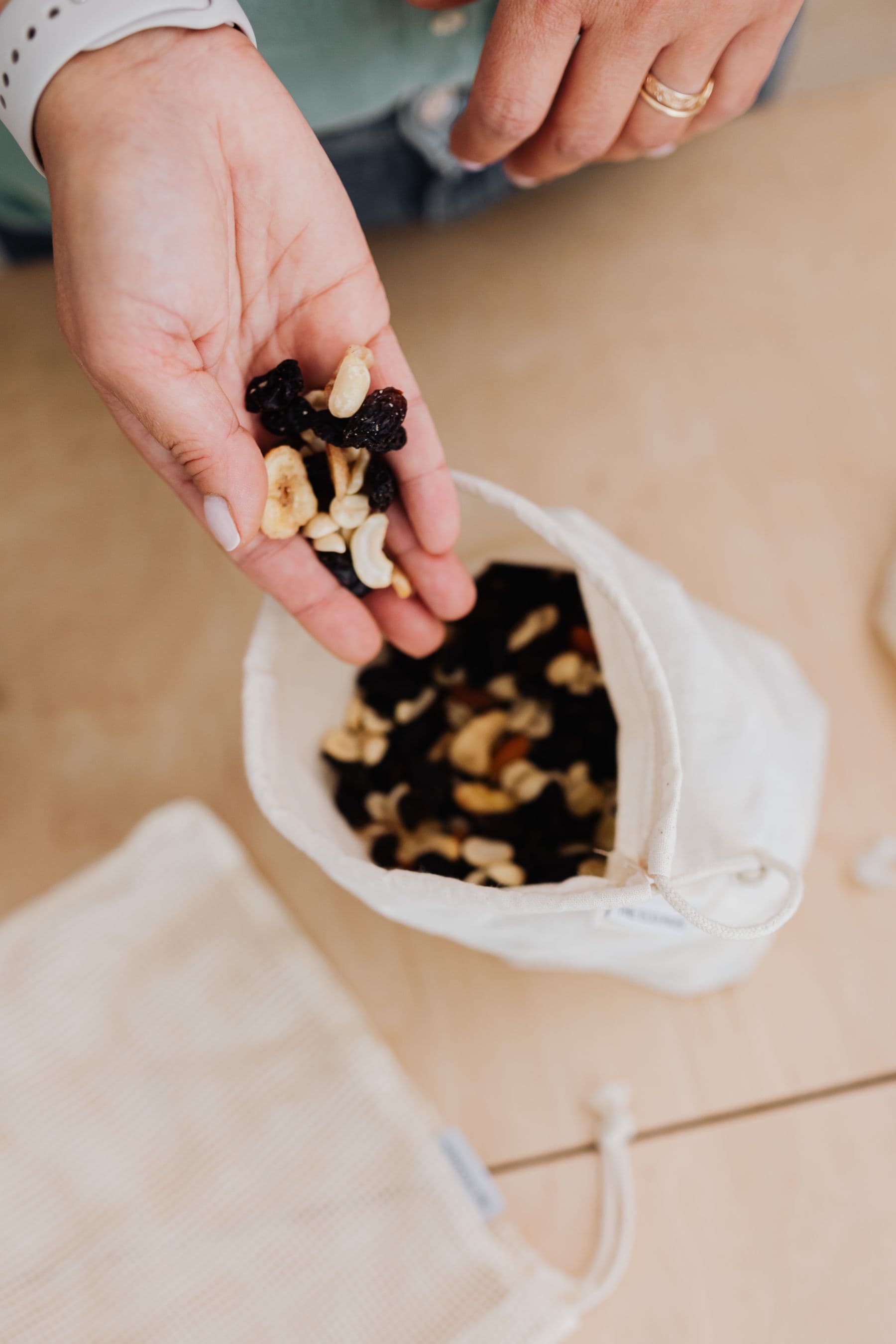 Hand holding a scoop of premium mixed nuts